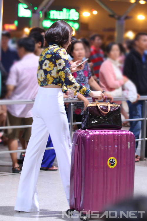 Dù đang kéo hành lý vào quầy check in nhưng Vân Trang không hề rời mắt khỏi điện thoại.
