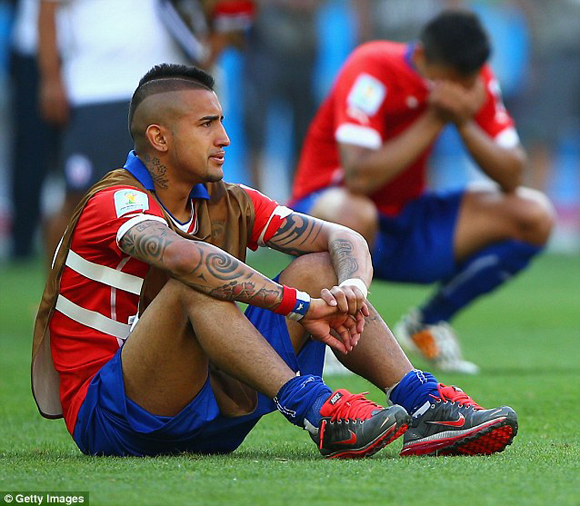 Một cầu thủ Chile ngồi thẫn thờ, phía sau anh là đồng đội đang khóc nức nở khi thua trận.
