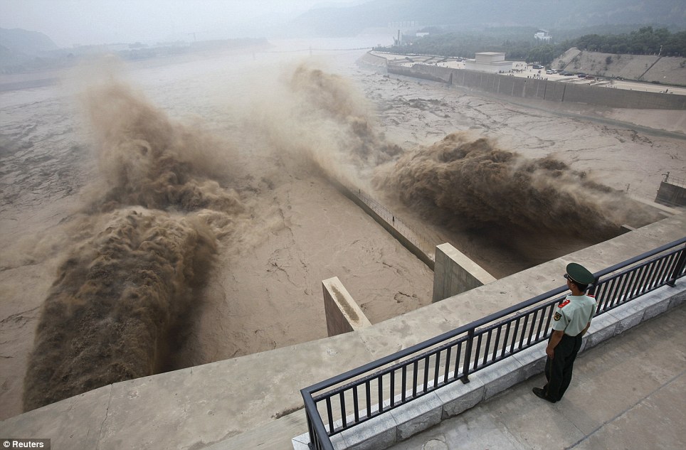 Một cảnh sát Trung Quốc đứng canh chừng hoạt động xả lũ của đập Xiaolangdi trên sông Hoàng Hà.