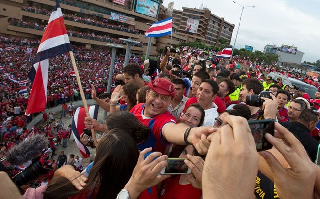 Đương kim Tổng thống Costa Rica, ông Luis Guillermo Solis (giữa) hòa vào đám đông người hâm mộ để mừng chiến thắng của tuyển quốc gia sau màn sút luân lưu với Hy Lạp.