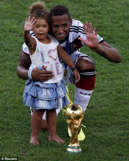 Jerome Boateng cùng con gái chụp ảnh với cúp vàng thế giới.