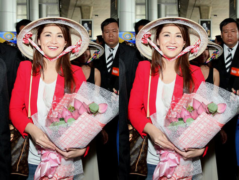 Cô vô cùng xinh đẹp trong nón lá, hoa sen tại sân bay.