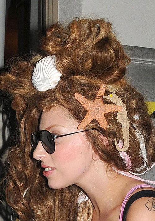 Lady Gaga như mang cả đại dương lên mái tóc với quá nhiều phụ kiện cầu kỳ mang biểu tượng sò, cá ngựa, sao biển… Không những thế, cách tạo kiểu tóc xù bồng khác người làm gương mặt lọt thỏm.