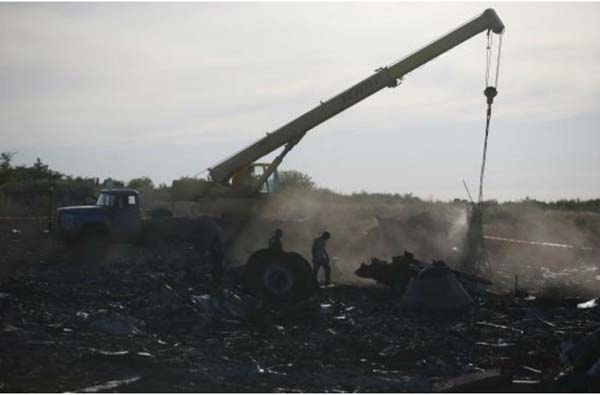 Nhân viên Bộ Khẩn cấp Ukraine dùng cần cẩu để di chuyển những mảnh vỡ máy bay MH17.