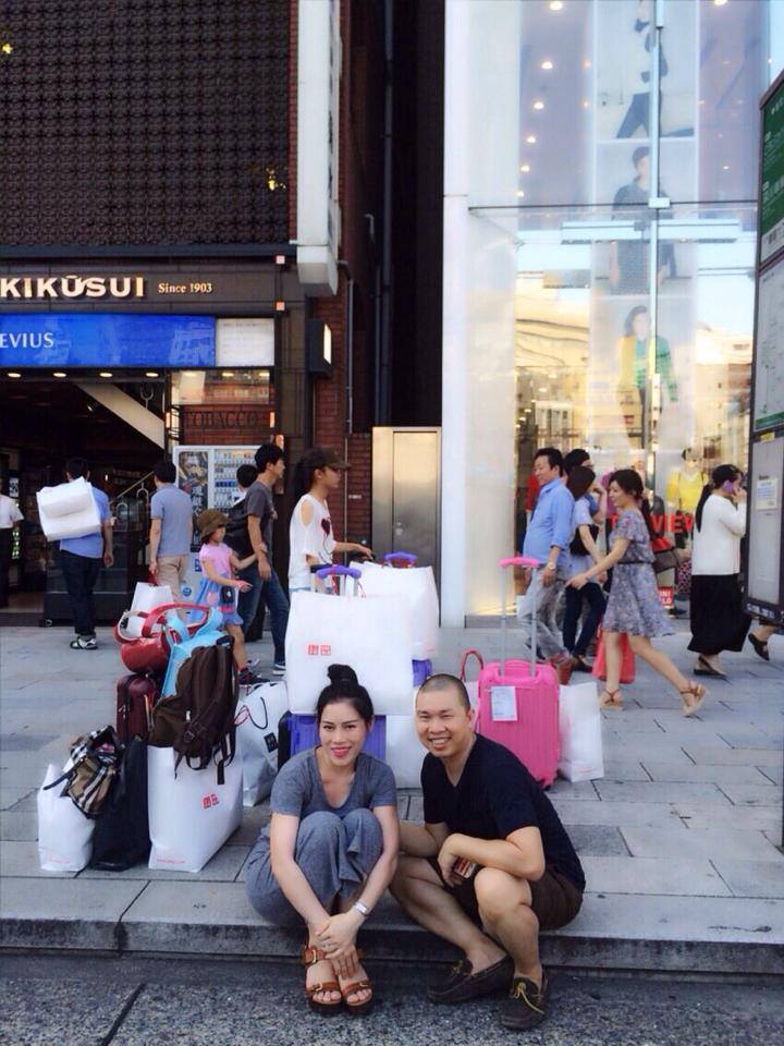 Diễn viên Hải Anh và vợ ngồi trước một "núi" đồ mua trong khi du lịch tại Nhật Bản với dòng chia sẻ hài hước: "Mua sắm dịu dàng ở Nhật".