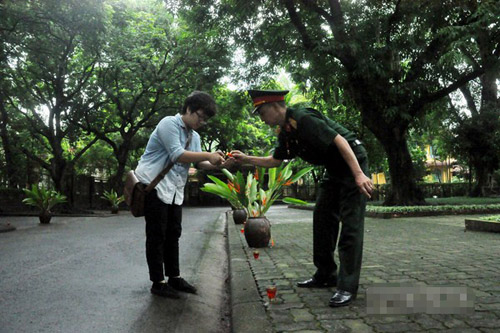 Phạm Vũ Quỳnh Chi - sinh viên năm nhất Đại học Xã hội và Nhân văn đến từ 6h sáng cùng cựu chiến binh Vũ Văn Anh thắp nến trong sân vườn nhà Đại tướng.