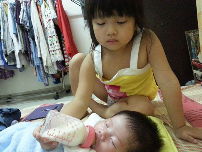 Con gái đầu của Dương Yến Ngọc rất ra dáng chị cả, giúp mẹ chăm em và cho em ăn.