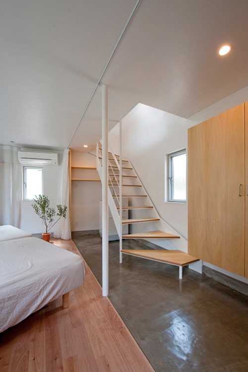 Cầu thang gỗ đơn giản dẫn lên tầng 2 là không gian sinh hoạt chung với phòng khách, phòng ăn, bếp và một phòng dự phòng.