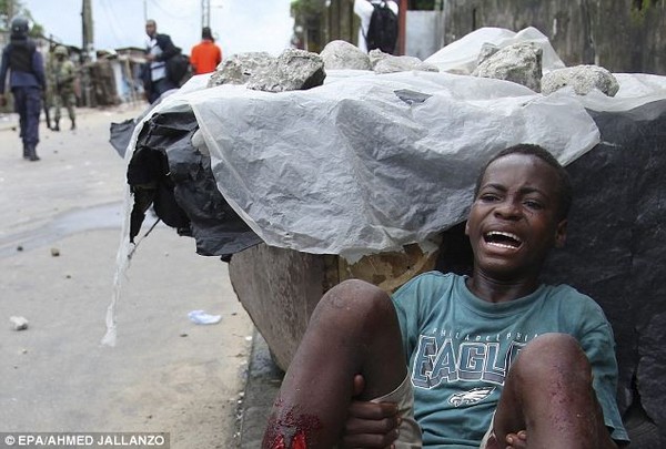 Chính phủ Liberia chọn khu ổ chuột West Poin ở thủ đô Monrovia làm vùng cách ly Ebola nhằm ngăn chặn dịch bệnh lây lan. Cư dân tại đây không được phép ra ngoài. Hơn 70.000 người bị mắc kẹt trong khu vực cách ly, họ đói ăn, tức giận và sợ hãi, những cuộc đụng độ đã xảy ra giữa người dân và lực lượng an ninh. Cậu bé trong ảnh đã hét lên vì đau đớn sau khi trúng đạn ở hai chân trong một cuộc đụng độ với lực lượng an ninh.