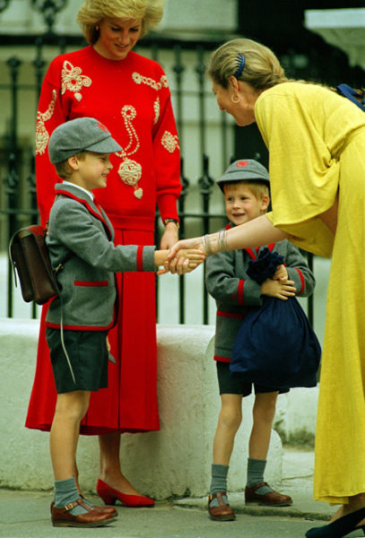 Hoàng tử William bắt tay hiệu trưởng Frederika Blair-Turner của trường Wetherby ở Notting Hill (Anh), trong khi em trai Harry, 4 tuổi, cầm túi đứng cạnh mẹ Công nương Diana vào ngày 11/9/1989. Đây là ngày đầu tiên tới trường của Hoàng tử Harry.