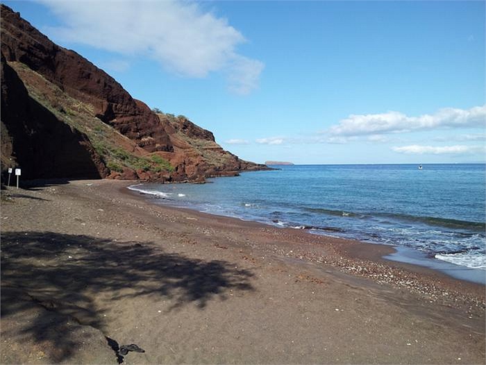 Cát đá đen nổi bật trên nền khung cảnh với biển xanh, sóng trắng ở bãi biển Oneuli, Maui.