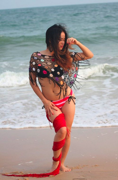 Bộ đồ bikini này của Đồng Lan sẽ thực sự sexy nếu cô chỉ mặc nguyên phần áo lưới thêu hoa sặc sỡ phía trên. Bù lại, chúng biến cô thành một cô nàng rắn biển với cách quấn khăn voan dọc một chân.
