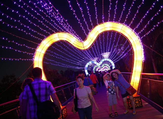 Khách tham quan tạo dáng dưới ánh đèn lung linh của lễ hội Trung thu ở Singapore.