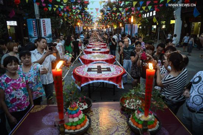 Người dân ở thành phố Hàng Châu, tỉnh Chiết Giang, Trung Quốc, chung tay làm mâm cỗ Trung thu dài trên đường phố với các loại bánh và món ăn truyền thống.