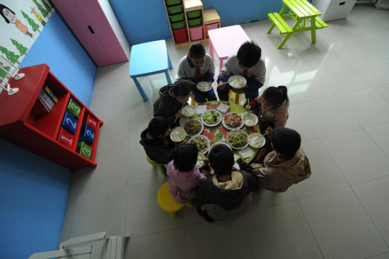 Trẻ em nhiễm HIV ngồi quay quần ăn tối. Trại mồ côi thuê giáo viên để dạy học cho những đứa trẻ không thể tới trường do sức khỏe yếu.