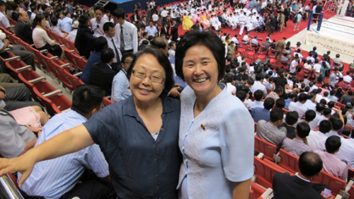 Một cư dân Hàn Quốc (trái) và một phụ nữ Triều Tiên (phải) cùng tới xem giải Đấu vật Chuyên nghiệp Quốc tế.