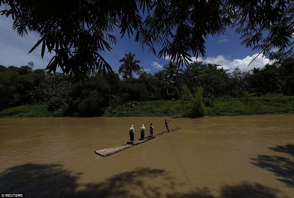Học sinh vượt sông bằng bè tre để tới trường học ở Lebak, Indonesia.
