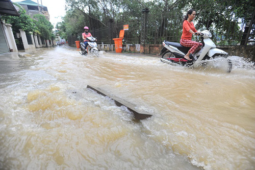 Nước từ sông Kỳ Cùng (Lạng Sơn) tràn vào phố qua đường cống tràn lên làm ngập các phố gần sông.