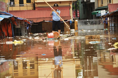 Nước lũ dâng cao đã làm ngập nhiều nơi trong chợ Giếng Vuông, nơi ngập sâu nhất tới gần 2m khiến người dân phải dùng bè di chuyển.