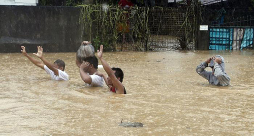 Những người dân đang ra hiệu cứu trợ khi đang ngập sâu trong nước.