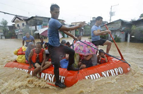 Người dân ở Marikina, Metro Manila, được sơ tán trên một chiếc thuyền cứu hộ sau khi nhà của họ bị lũ lụt nhấn chìm.
