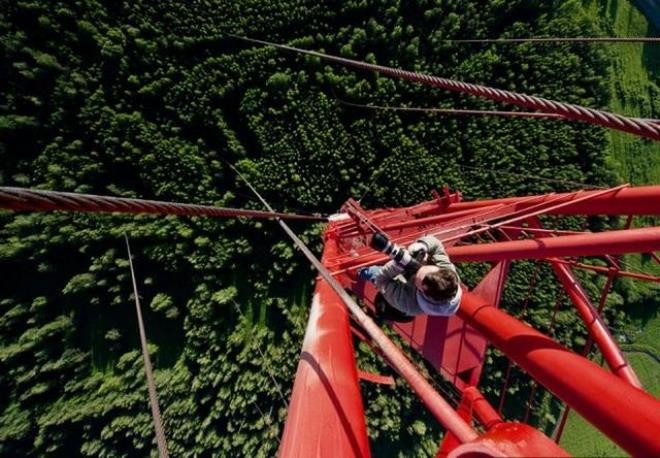 Vì quá tò mò nên nhiếp ảnh gia người Nga đã liều mình leo lên chiếc cầu màu đỏ.