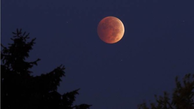 Đĩa mặt trăng đang chuyển dần từ màu cam sang màu đỏ trong bức ảnh do người yêu thiên văn chụp tại thành phố Erie, bang Pennsylvania, Mỹ.