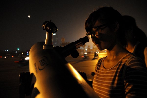 Các bạn trẻ lần lượt thay nhau nhìn vào ống kính thiên văn để ngắm 'trăng máu'.
