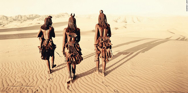 Những người phụ nữ thuộc bộ tộc Himba đi bộ qua sa mạc. Tộc người này sinh sống chủ yếu ở phía tây bắc Namibia và tây nam Angola. Mặc dù cuộc sống trở nên khó khăn hơn bởi các dự án thủy diện trên sông Kunene, nhưng người Himba vẫn tiếp tục sinh tồn đến ngày nay.