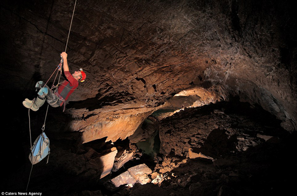 Một nhà thám hiểm người Anh đang trèo lên một sợi dây thừng để ra ngoài từ hang động khổng lồ được gọi là  Whiterock River, sâu dưới lòng đất ở Clearwater Cave.