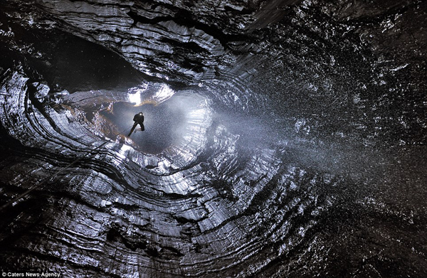 Một nhà thám hiểm đang trèo lên khỏi hang động ẩm ướt.
