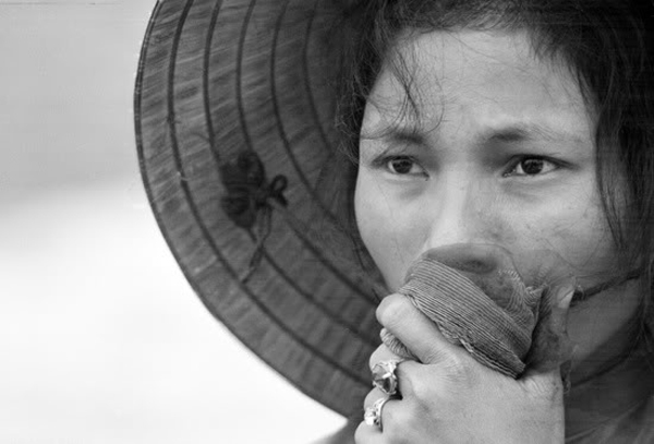 Một phụ nữ VN đang nhìn trân trân ngôi mộ tập thể nhóm Việt Cộng được khai quật tại làng Điện Bái, phía đông của Huế vào tháng 04/1969. Chồng, bố và em trai của cô đã ra đi và mất tích từ dịp tết Mậu Thân, cô lo sợ họ đã bị giết.