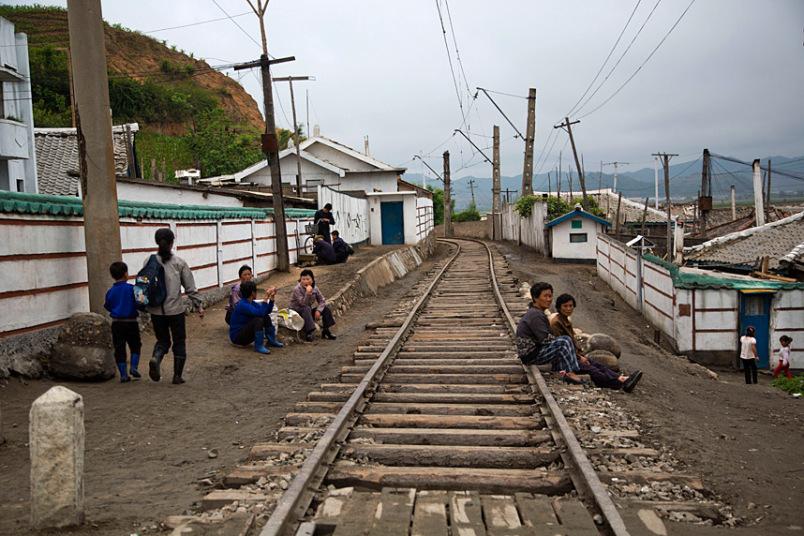 Người dân ngồi nghỉ ngơi cạnh đường ray tàu hỏa.