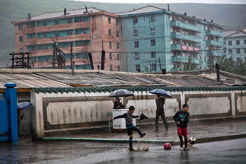 Các cậu bé chơi bóng đá dưới mưa tại thị trấn Hyesan, tỉnh Ryanggang.