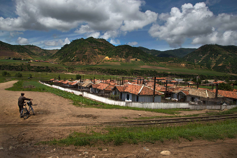Người đàn ông dắt xe đạp qua đường ray tàu hỏa để vào một ngôi làng ở tỉnh Bắc Hamgyong.