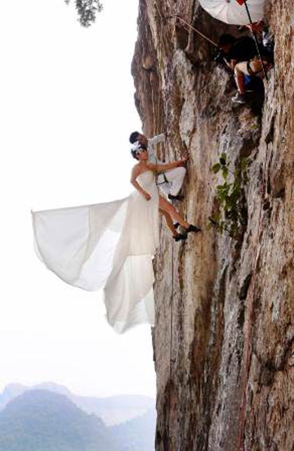 Một cặp tình nhân ở Trung Quốc quyết định hưởng ứng trào lưu này của thế giới bằng cách leo lên vách núi 20m để chụp ảnh cưới.