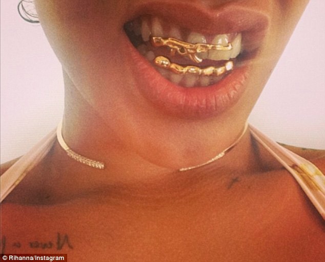 Rihanna gây sốc khi khoe bộ răng bọc vàng. Đặc biệt là hàm trên được đúc theo hình súng.