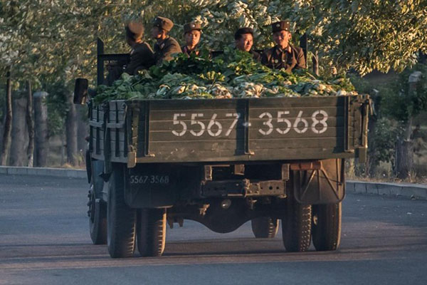 Quân nhân Triều Tiên ngồi trên xe chở rau cải.