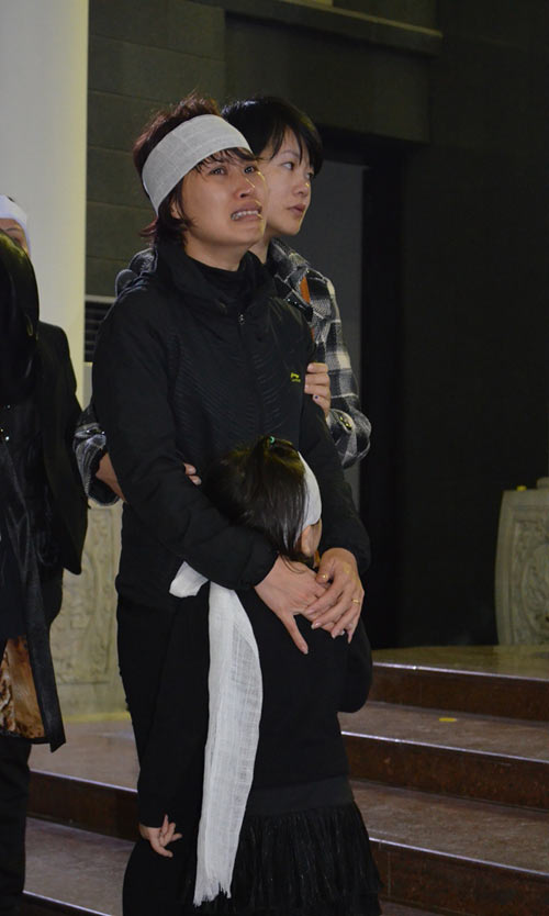 Chị Lê Thị Ngọc Hà (31 tuổi) khóc lịm người bên đứa con gái nhỏ.