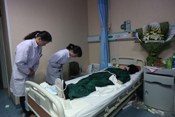 Bác sĩ của Bệnh viện đang cúi đầu bên thi thể Hoàng Tĩnh trước khi lấy giác mạc.