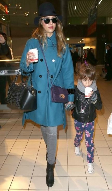 Nữ diễn viên cùng con gái xuất hiện tại sân bay với chiếc túi nhỏ màu tím của Jimmy Choo, quần jean J.Brand và áo khoác Sportmax.