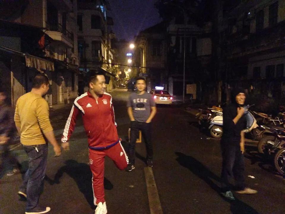 Tuấn Hưng khởi động để đá bóng trên phố buổi tối.