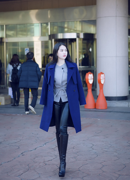 Áo sơ mi cách điệu, kết hợp áo khoác dạ dáng dài phối với quần da và bốt cao ngang gối, giúp Ngọc Trinh nổi bật trên đường phố Seoul.