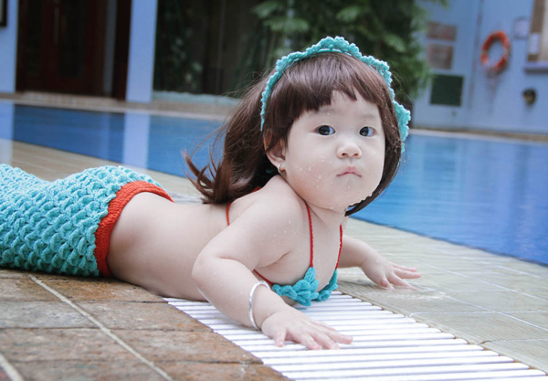 Con gái Lý Hải mặc bộ bikini đặc biệt, ngây thơ tạo dáng bên hồ bơi.