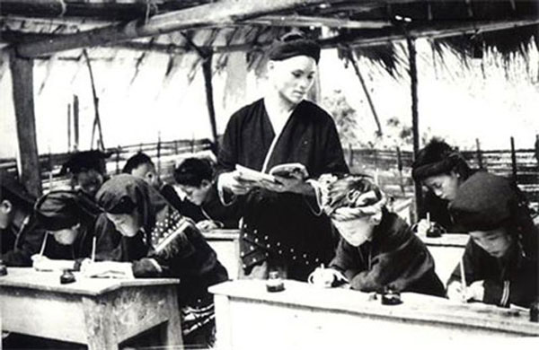Hình ảnh thầy giáo người Dao giảng dạy trong lớp học Bình dân học vụ, xóa mù chữ cho các học trò tại Đà Bắc, Hòa Bình sau khi nước ta giành dộc lập năm 1945.