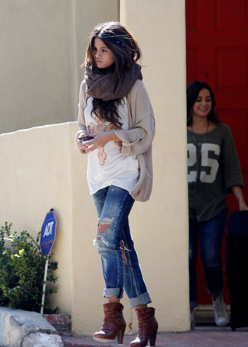 Quần jeans rách cá tính xắn gấu kết hợp ankle boots cũng là kiểu trang phục 'ruột' của Selena.
