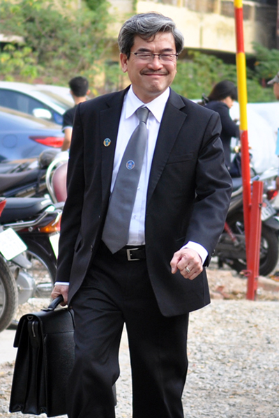 Luật sư Nguyễn Huy Thiệp, một trong bốn người bào chữa cho bị cáo Nguyễn Đức Kiên, cười tươi trước khi vào tòa.