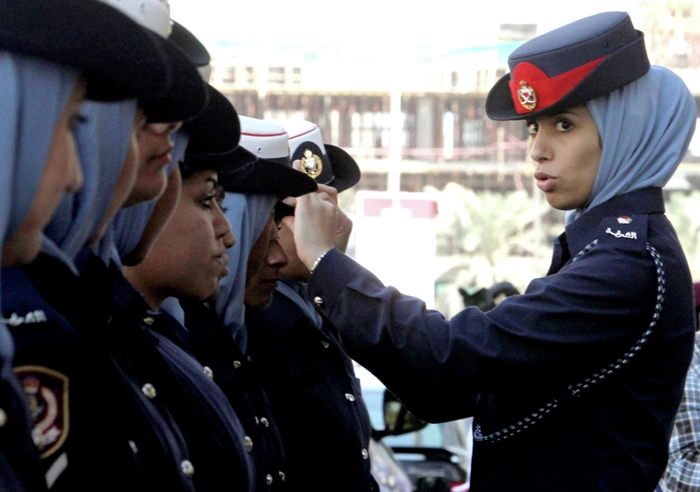 Nữ cảnh sát Bahrain chỉnh đốn lại quân phục cho đồng nghiệp bên ngoài một tòa án ở Manama.