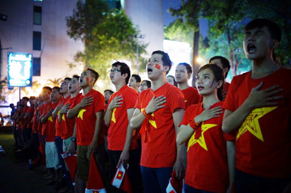 CĐV Việt Nam hát quốc ca khi xem trận VN - Malaysia qua màn hình lớn tại Nhà văn hóa Thanh Niên TP.HCM.