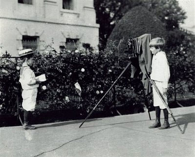 Quentin (trái) và Archibald Roosevelt, hai cậu con trai của Tổng thống Theodore Roosevelt, đang nghịch máy ảnh của Frances B. Johnston trong một buổi chụp ảnh ngoài trời tại Nhà Trắng vào khoảng năm 1902.